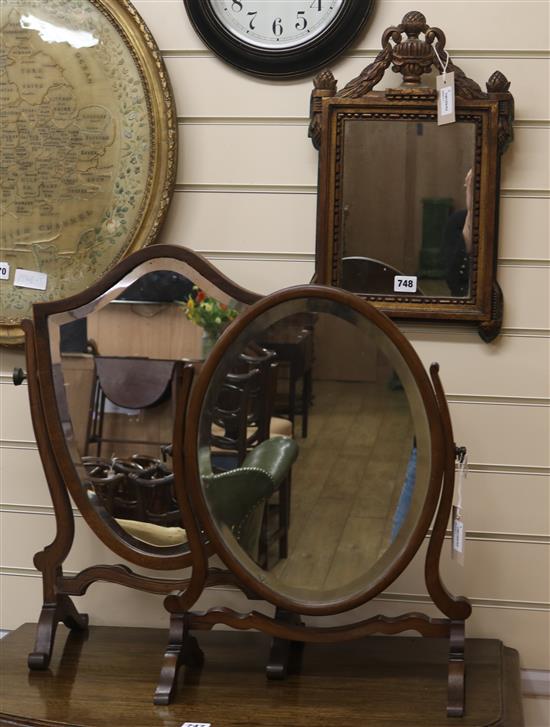 A mahogany shield-shaped skeleton toilet mirror, a similar oval mirror and a gilt-framed wall mirror with urn and swag pediment (3) H.5